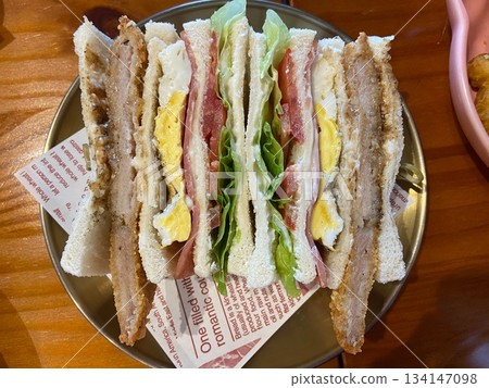 Club sandwich with fried pork chop and egg 134147098