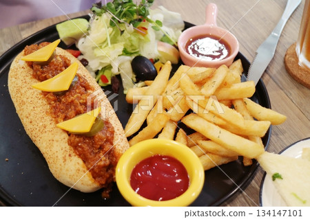 Chili hot dogs with fries and salad Chili hot dogs with fries and salad 134147101