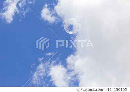 Soap bubble floating in the blue sky with white clouds, freedom and celebration Soap bubble floating in the blue sky with white clouds, freedom and celebration 134150105