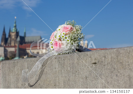 Wedding bouquet resting on stone wall overlooking prague castle 134150137