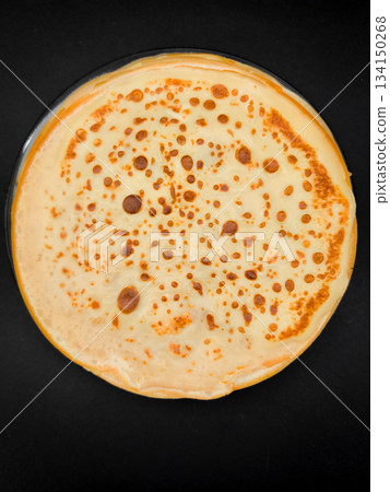 Delicious homemade crepe resting on dark background, ready for breakfast maslenitsa or shrove tuesday 134150268
