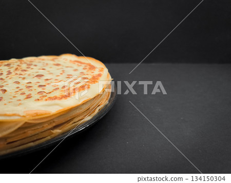 Stack of pancakes resting on dark surface for pancake day maslenitsa or shrove tuesday with copy space 134150304