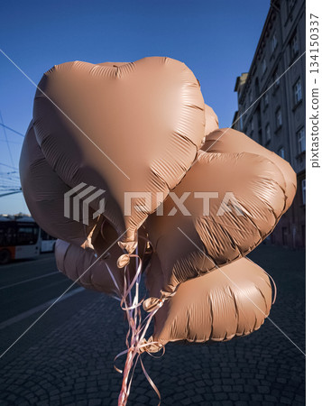 Brown mocha mousse heart shaped balloons soaring in prague's blue sky Brown mocha mousse heart shaped balloons soaring in prague's blue sky 134150337