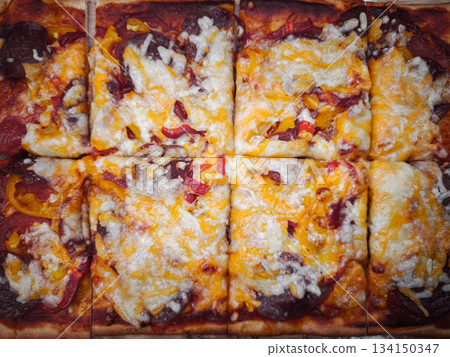 Delicious square pizza with salami, bell peppers and melted cheese Delicious square pizza with salami, bell peppers and melted cheese 134150347
