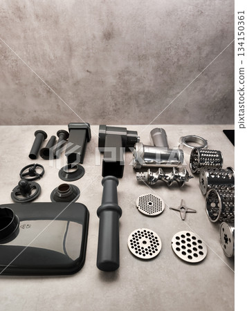 Disassembled meat grinder parts lying on kitchen counter Disassembled meat grinder parts lying on kitchen counter 134150361