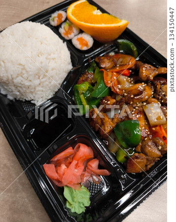 Delicious bento box filled with teriyaki chicken, rice, sushi, and condiments lunch fast food Delicious bento box filled with teriyaki chicken, rice, sushi, and condiments lunch fast food 134150447