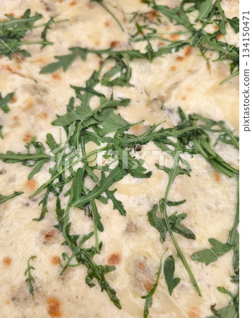 Delicious lasagna with fresh arugula covering creamy bechamel sauce Delicious lasagna with fresh arugula covering creamy bechamel sauce 134150471