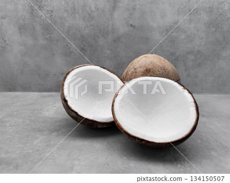 Fresh coconuts showing white flesh on gray background. Copy space, banner Fresh coconuts showing white flesh on gray background. Copy space, banner 134150507