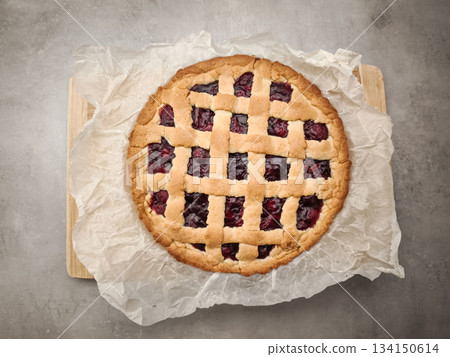 Homemade cherry pie rests on baking paper over a wooden board, creating a tempting breakfast scene for valentine's day in prague 134150614