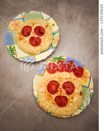 Cheerful valentine's breakfast featuring two heart shaped omelets adorned with cherry tomato smiley faces on vibrant plates Cheerful valentine's breakfast featuring two heart shaped omelets adorned with cherry tomato smiley faces on vibrant plates 134150620