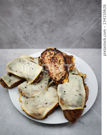 French toast with cheese on white plate, indulging in sweet and savory breakfast delight 134150626