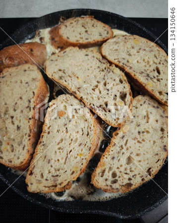 Slices of whole wheat bread frying in butter in a pan for breakfast Slices of whole wheat bread frying in butter in a pan for breakfast 134150646