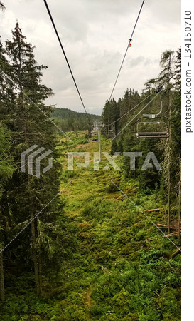 Chairlift descending into lush valley in high tatras mountains, slovakia Chairlift descending into lush valley in high tatras mountains, slovakia 134150710