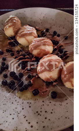 Potato dumplings with chocolate and blueberries served on plate in slovakia strbske pleso, high tatras 134150724