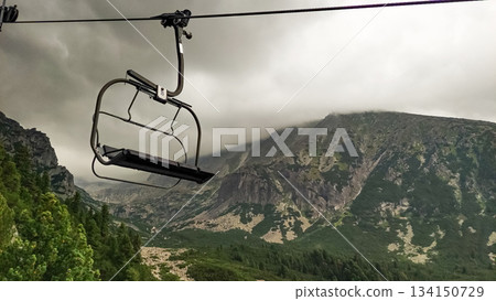 Empty chairlift hanging over mountain valley in the high tatras, slovakia Empty chairlift hanging over mountain valley in the high tatras, slovakia 134150729