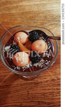 Delicious chocolate pudding with biscuits, blackberries and candied orange zest on wooden table strbske pleso, high tatras 134150733