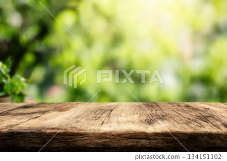 Radiant green spring background panorama with wooden table for a concept 134151102