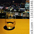Scene of a glass of white wine with a big city night view in the background 134151446