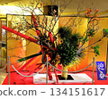 A large flower arrangement in the hotel lobby with a gold folding screen in the background 134151617