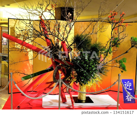 A large flower arrangement in the hotel lobby with a gold folding screen in the background 134151617