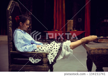 Ballerina resting in chair backstage during performance preparation Ballerina resting in chair backstage during performance preparation 134151741