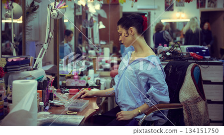 Ballerina organizing accessories in busy backstage dressing room Ballerina organizing accessories in busy backstage dressing room 134151750