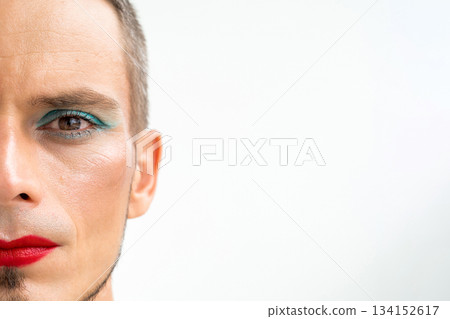portrait of a gay male with makeup and cosmetics on face on a white background. Man with red lipstick on lips and mascara on eyes portrait of a gay male with makeup and cosmetics on face on a white background. Man with red lipstick on lips and mascara on eyes 134152617