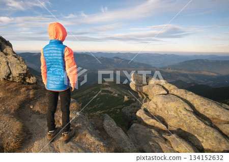 Young child boy hiker standing in mountains enjoying view of amazing mountain landscape. Young child boy hiker standing in mountains enjoying view of amazing mountain landscape. 134152632
