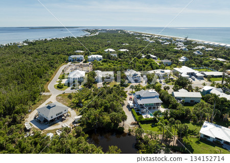 Wealthy neighborhood in small town Boca Grande, Florida with expensive waterfront houses between green palm trees. Development of US premium housing Wealthy neighborhood in small town Boca Grande, Florida with expensive waterfront houses between green palm trees. Development of US premium housing 134152714