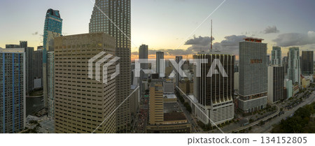 View from above of skyscraper buildings and urban traffic in downtown district of Miami Brickell in Florida, USA at sunset. American megapolis with business financial district at nightfall View from above of skyscraper buildings and urban traffic in downtown district of Miami Brickell in Florida, USA at sunset. American megapolis with business financial district at nightfall 134152805