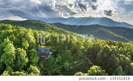USA travel destination. Mount Mitchell and remote house in mountain sunrise forest illuminated with bright rising sun in North Carolina Appalachian mountains. Tourist shelter on hillside 134152819
