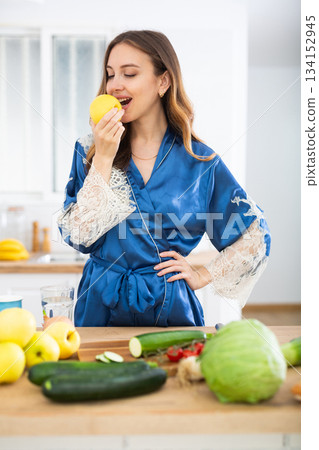 Portrait of positive woman eating apple at home 134152945