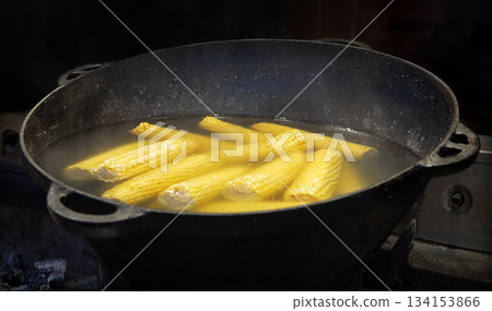 Yellow corn is cooked in a large cauldron 134153866