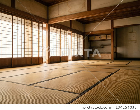 dojo features tatami mats on the floor. Soft daylight comes through paper screens creating a warm atmosphere in the room. It is an empty space ready for activities. dojo features tatami mats on the floor. Soft daylight comes through paper screens creating a warm atmosphere in the room. It is an empty space ready for activities. 134154033