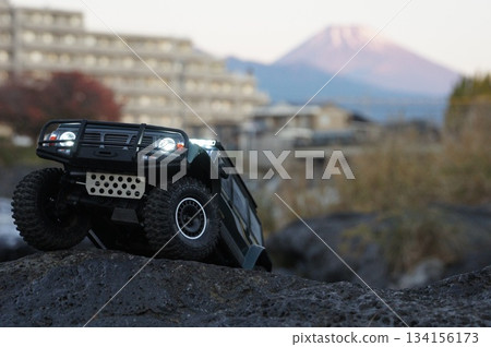 A radio-controlled SUV driving through the rocky terrain of nature A radio-controlled SUV driving through the rocky terrain of nature 134156173