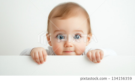 baby peeking over the edge with big eyes. 134156359