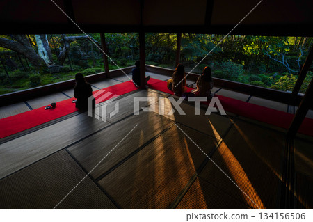 Back view of people sitting on the stool and looking at the garden at Hosen-in Temple in Ohara, Kyoto Back view of people sitting on the stool and looking at the garden at Hosen-in Temple in Ohara, Kyoto 134156506