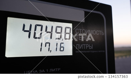 Fuel price display with digital readout at gas station during sunset 134157363