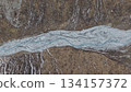 Aerial view of winding river through rocky terrain with natural textures 134157372