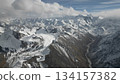Snow-capped mountain range with dramatic clouds and rugged terrain 134157382