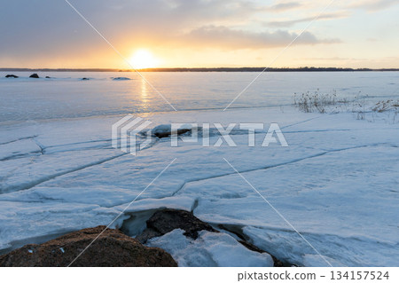 Coastal granite rocks are covered with ice and snow. Winter landscape Coastal granite rocks are covered with ice and snow. Winter landscape 134157524