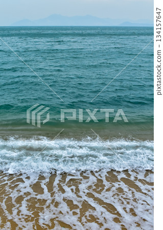 Close-up of soft waves sand beach and blue sea. Texture of water, white foam waves. Seascape, Sea background, Sea water with copy space, summer vacation concept.  134157647