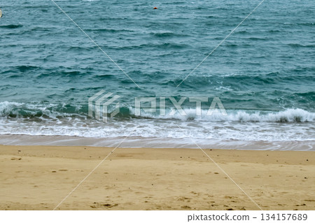 Close-up of soft waves sand beach and blue sea. Texture of water, white foam waves. Seascape, Sea background, Sea water with copy space, summer vacation concept. Close-up of soft waves sand beach and blue sea. Texture of water, white foam waves. Seascape, Sea background, Sea water with copy space, summer vacation concept. 134157689