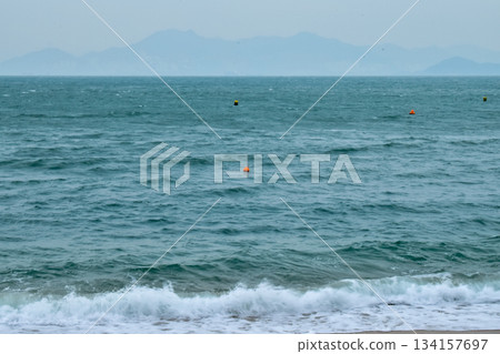 Close-up of soft waves sand beach and blue sea. Texture of water, white foam waves. Seascape, Sea background, Sea water with copy space, summer vacation concept. Close-up of soft waves sand beach and blue sea. Texture of water, white foam waves. Seascape, Sea background, Sea water with copy space, summer vacation concept. 134157697