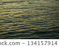 Reflection of golden sunlight on water. Sunset sea view with sparkle sunlight. Sunset light hitting on the ocean. Sunset sea background. 134157914