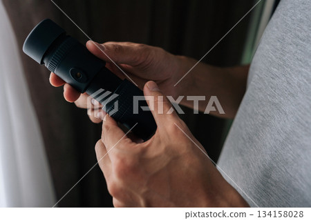 Person holding monocular, observing, exploring, looking into distance, focusing on details with optical equipment, emphasizing vision and search. Concept of discovering, exploring, vision. 134158028