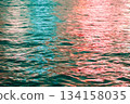 Reflection of city light on water at night. Night sea view with street light. Light hitting on the ocean.Sea background. Background of the calm water, water waves. Sea water surface. 134158035