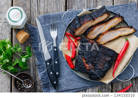 charred pork chunk served on a metal tray 134158310