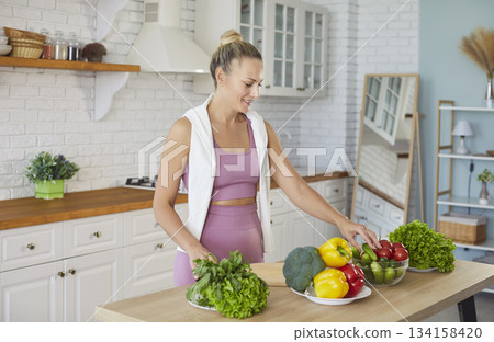Healthy diet for strong fit young woman, happy athlete cooking salad before training at home 134158420