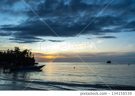 Sunset with pirogue at Lia Beach, Waleakodi Island, Togian archipelago, Indonesia Sunset with pirogue at Lia Beach, Waleakodi Island, Togian archipelago, Indonesia 134158530